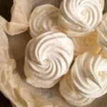 Meringue in a paper bag on a wooden table.