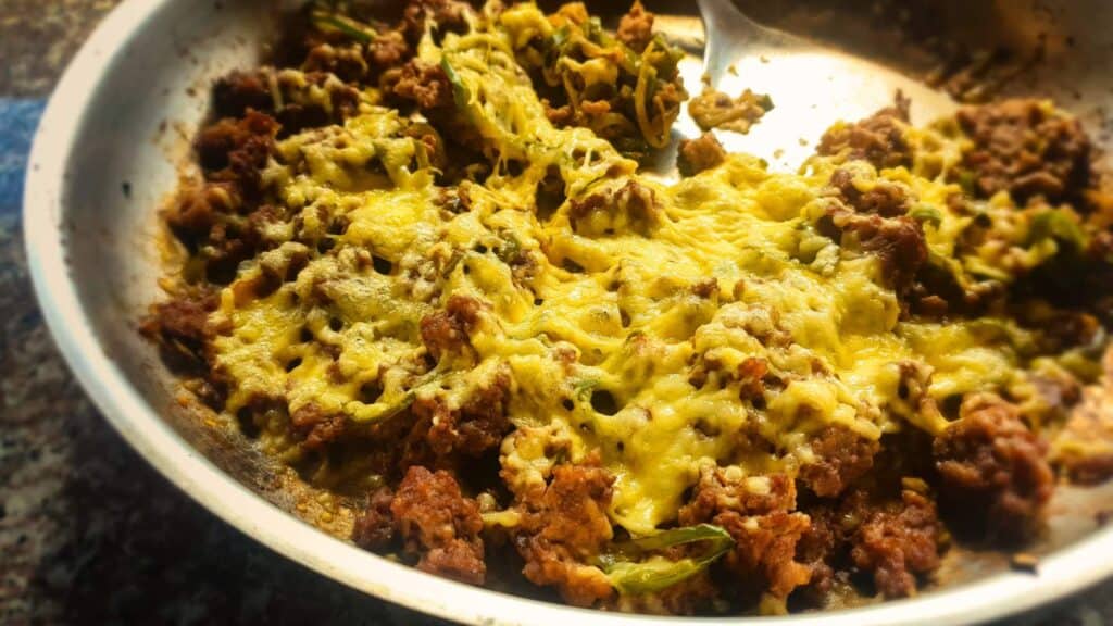 A skillet filled with meat and cheese.