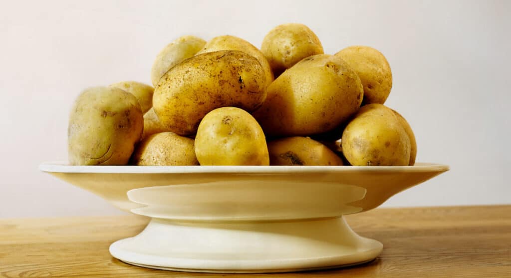 A bowl full of potatoes on a table.