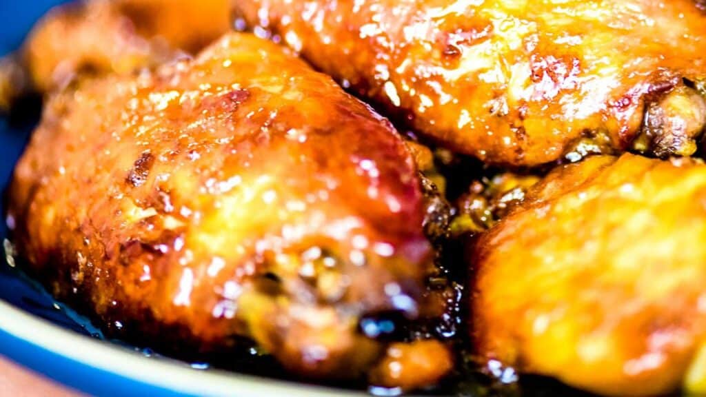 Chicken wings in a blue bowl on a wooden table.