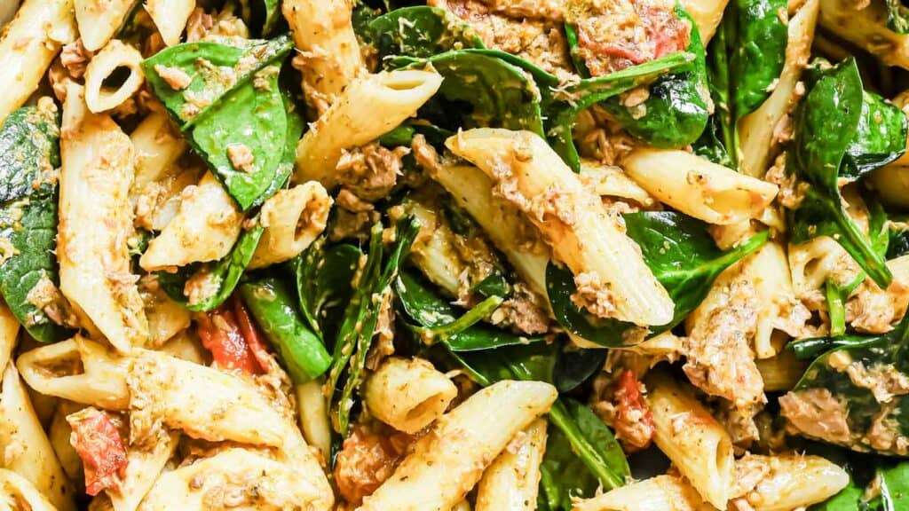 A close up of pasta with spinach and tuna.