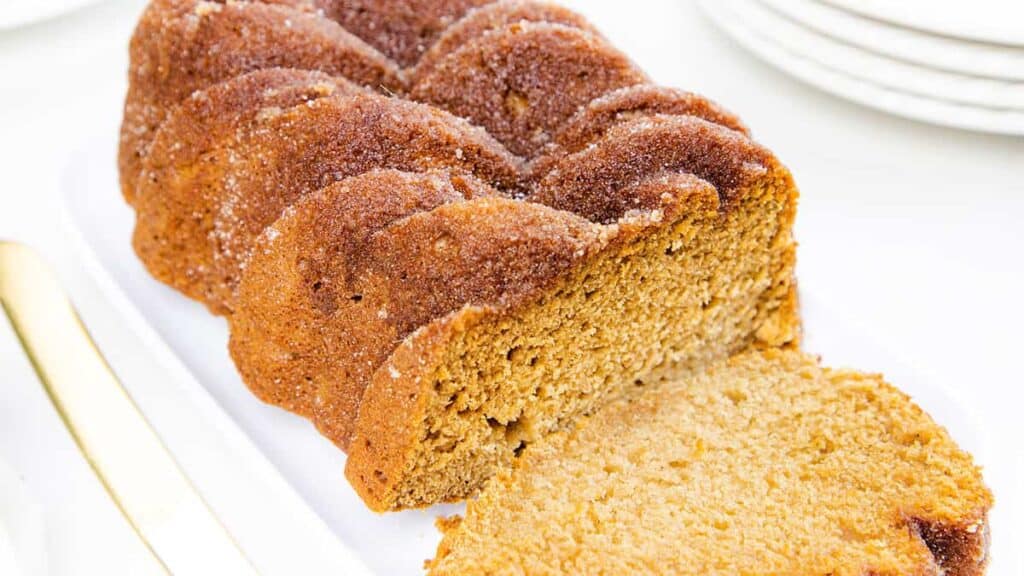 A sliced applesauce bread on a white plate.
