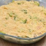 A freshly baked broccoli casserole in a glass dish, topped with golden breadcrumbs.