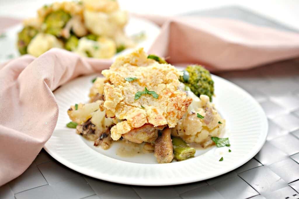 A plate of cauliflower and broccoli casserole garnished with fresh herbs.