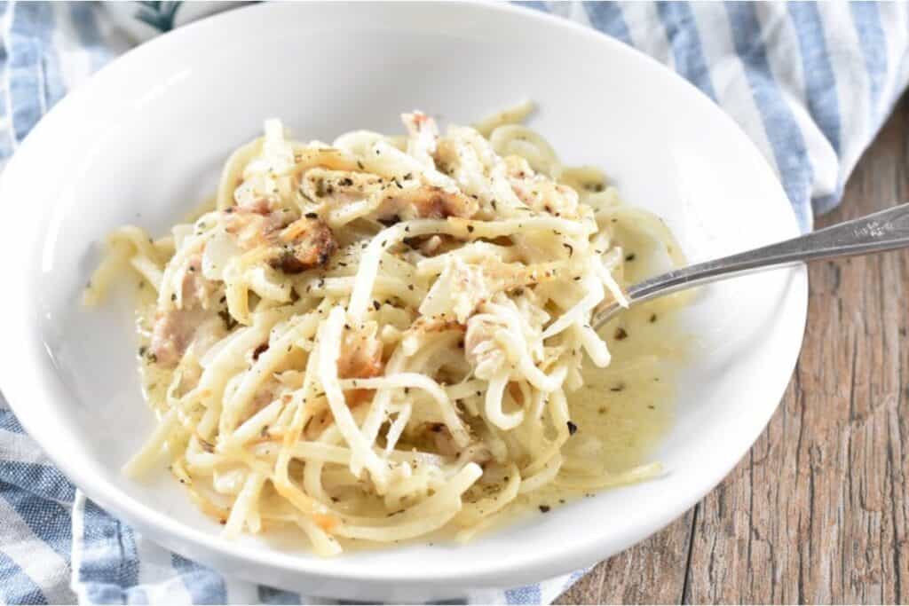 A bowl of creamy tetrazzini with a fork.