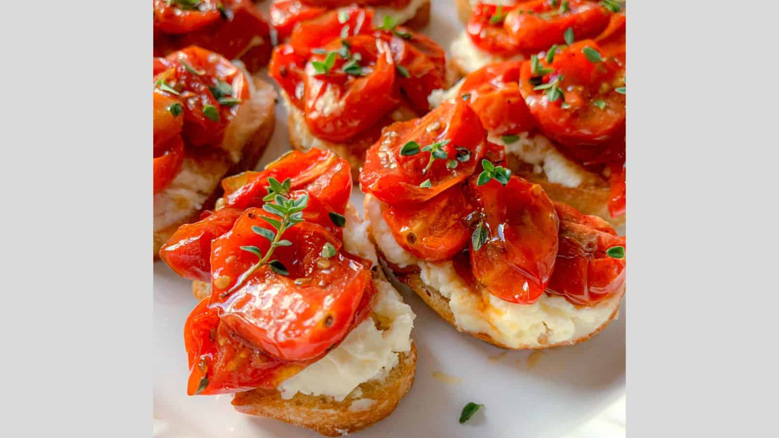 Roasted tomatoes atop toasted bread rounds with feta cheese.