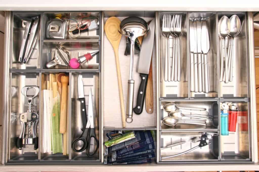 A kitchen drawer full of utensils and utensils.