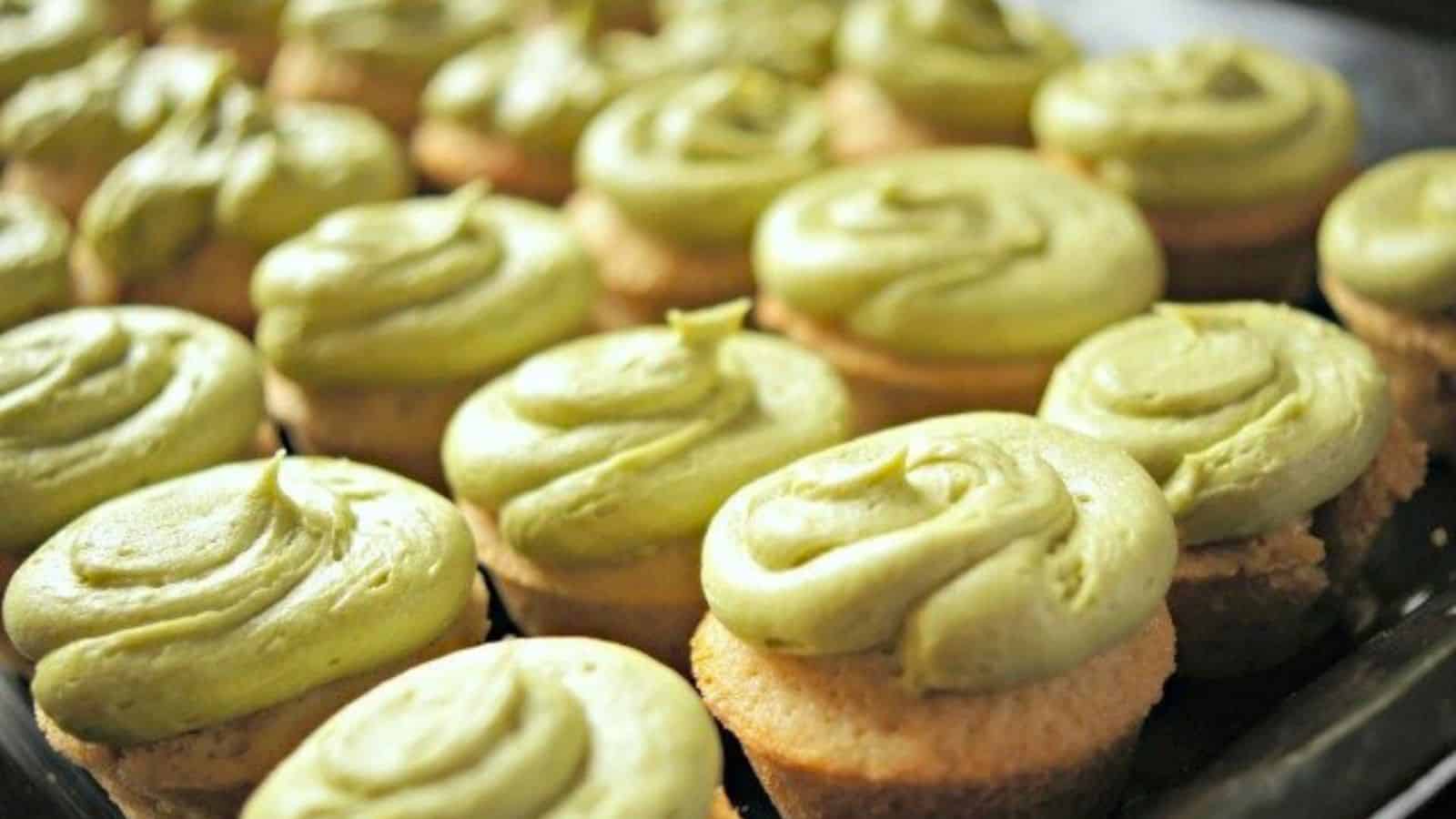 Image shows A tray of green tea cupcakes with matcha frosting on them.