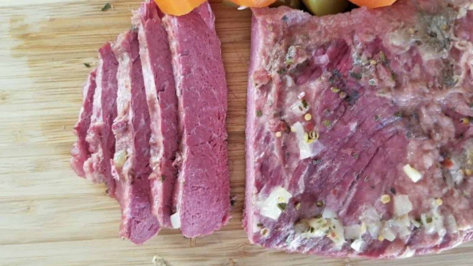 Image shows  Corned beef and veggies on a cutting board.