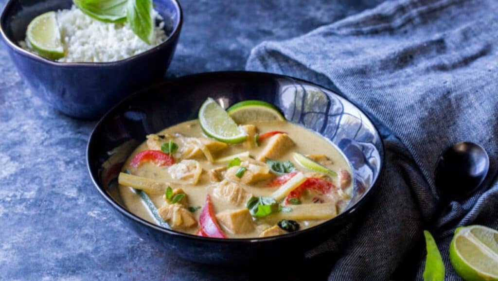 Thai green chicken curry in a black bowl.