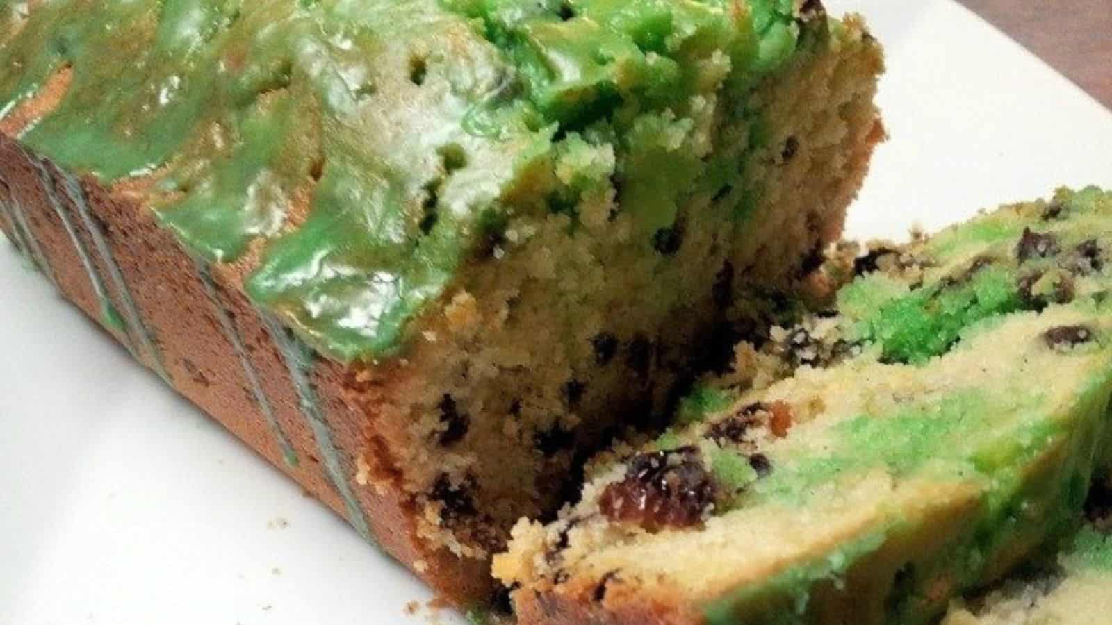 Image shows A slice of an Irish tea cake with green icing is on a plate.