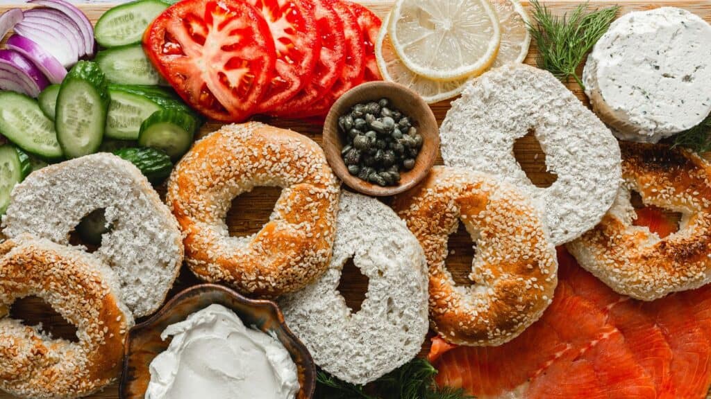 A selection of bagels perfect for brunch recipes, served with cream cheese, smoked salmon, capers, and fresh vegetables.