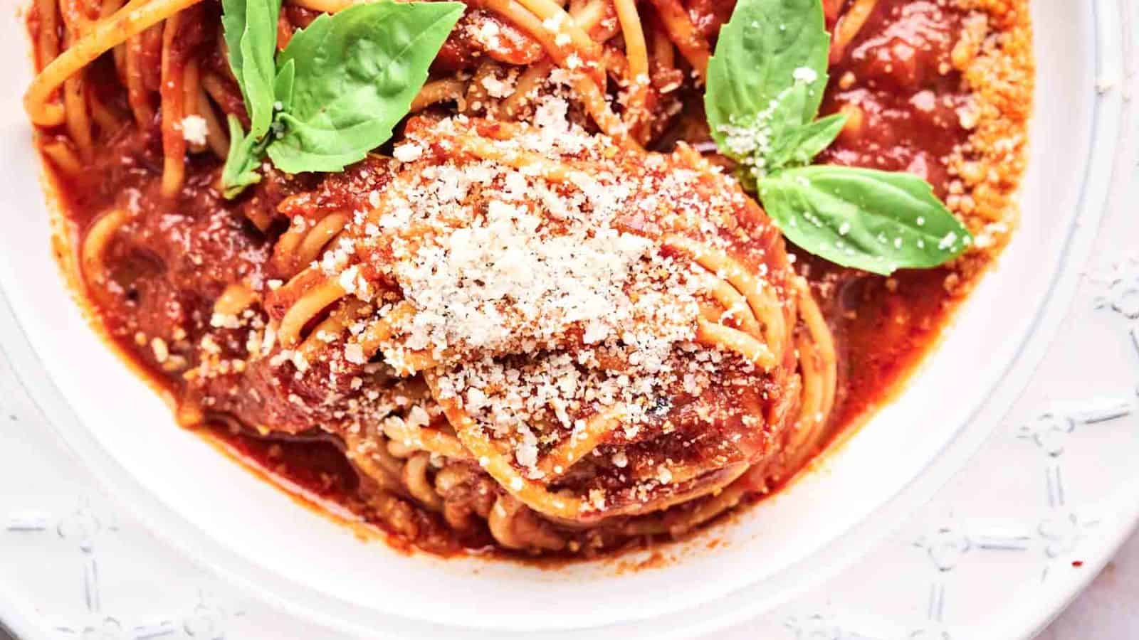 Spaghetti marinara in a bowl with fresh basil on top..