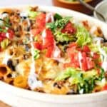 Baked pasta with melted cheese, fresh tomatoes, lettuce, and a creamy dressing.