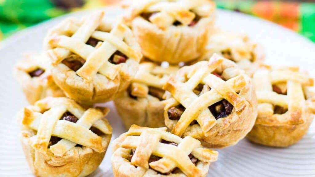 Miniature pies with lattice crusts on a plate.