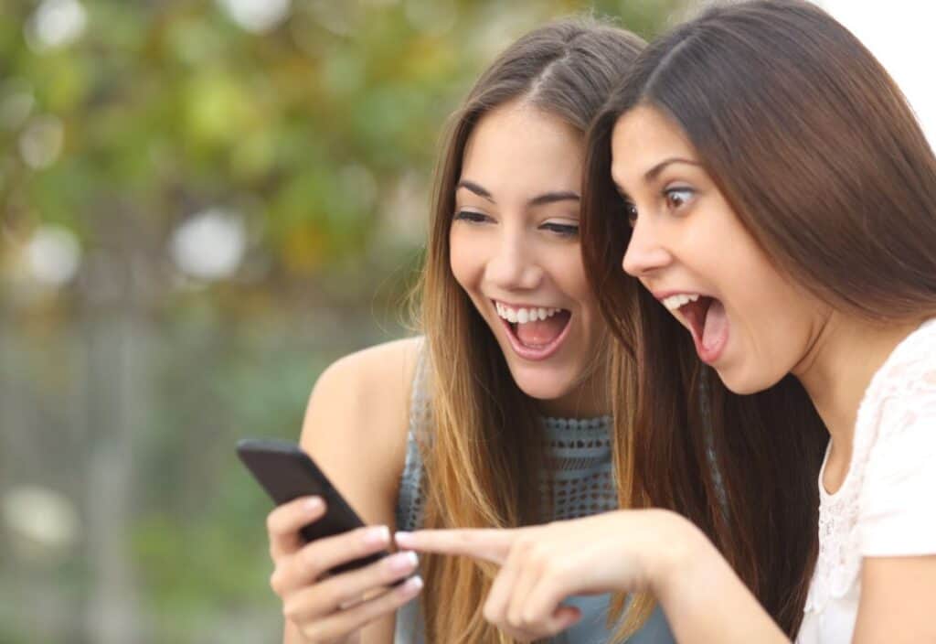 Two young women looking at a cell phone.