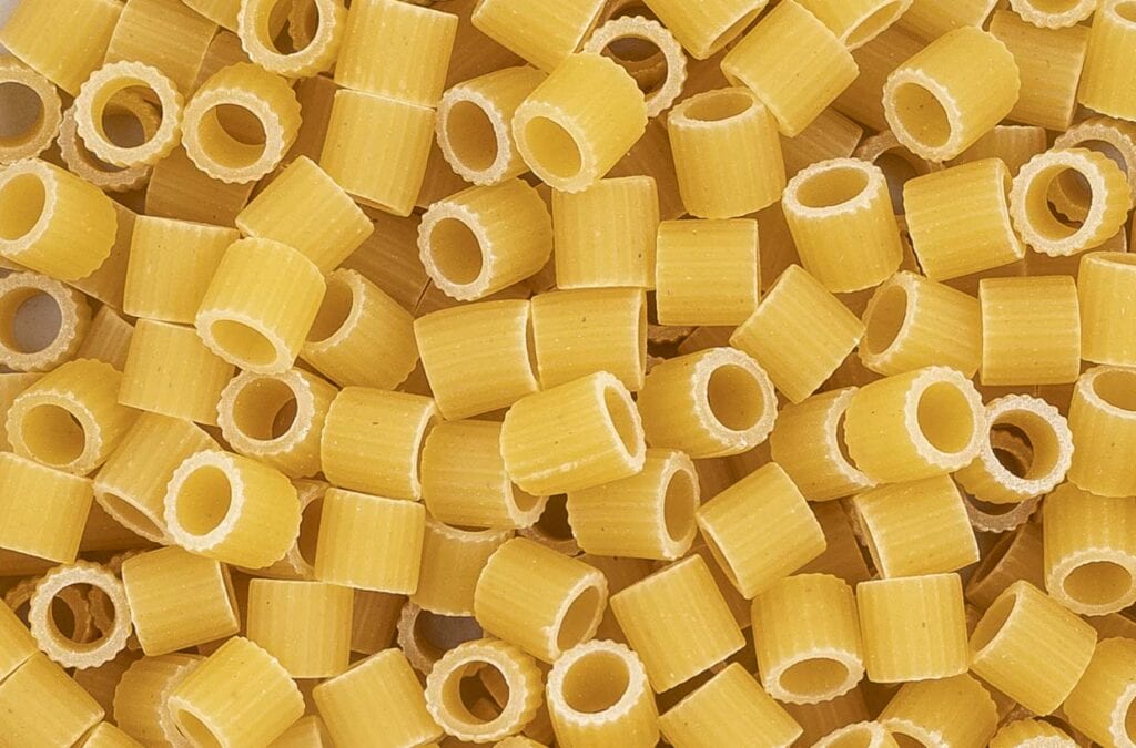 Close-up of uncooked ditalini pasta arranged randomly.