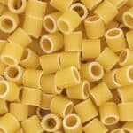 Close-up of uncooked ditalini pasta arranged randomly.