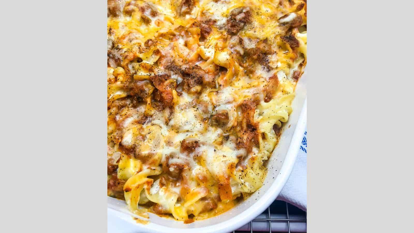 Noodles and ground beef are mixed with a cheesy topping together in a creamy casserole.