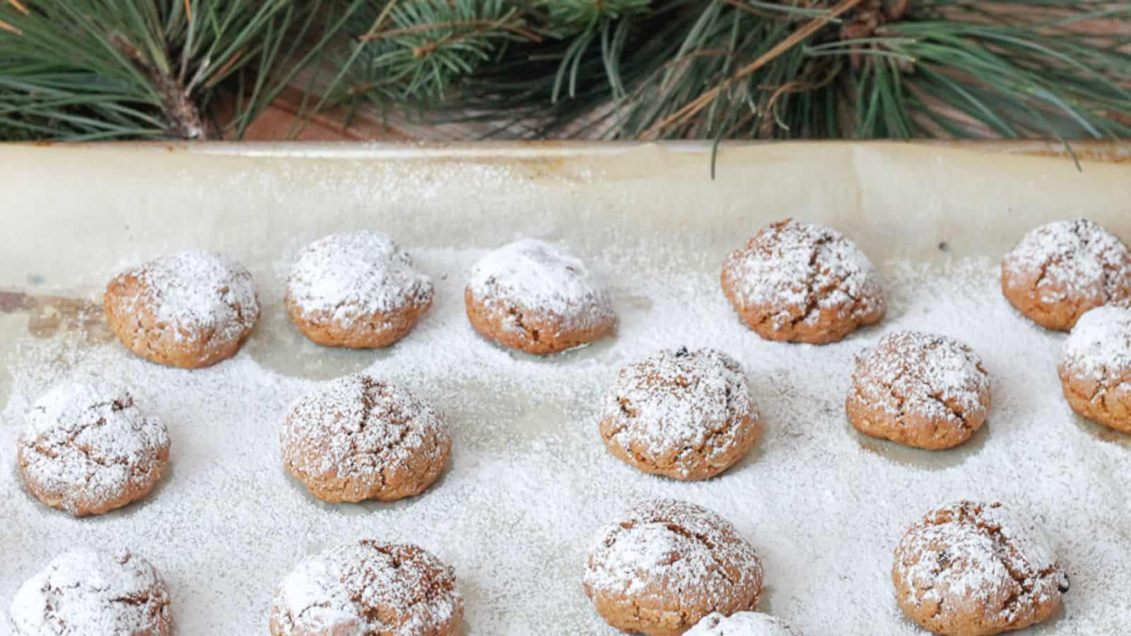 Powdered sugar covered cookies on a baking sheet.