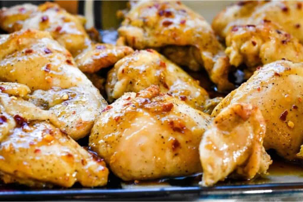 Seasoned chicken pieces on a baking tray.