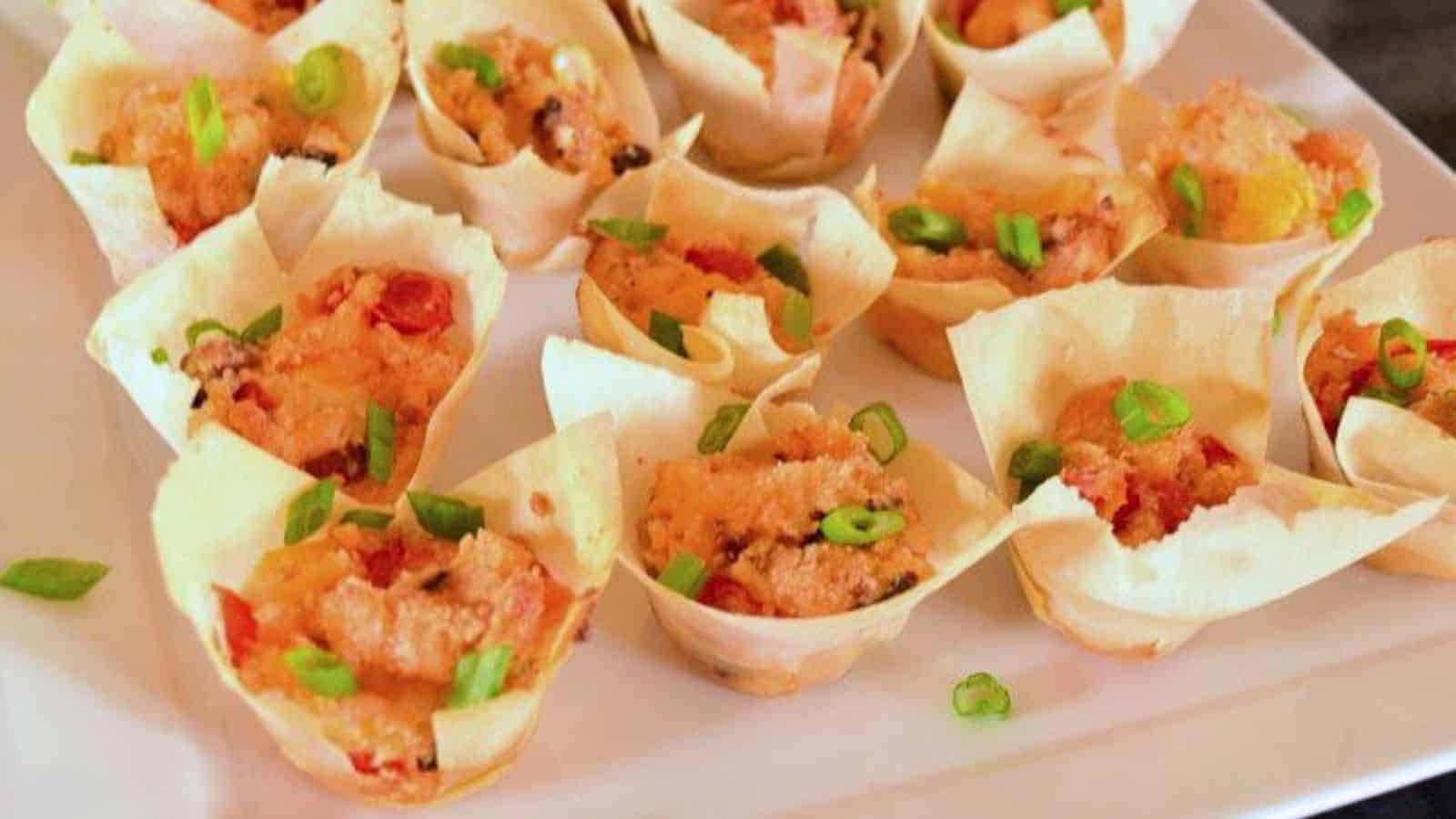 Image shows a white plate with tomato bacon cups on it.