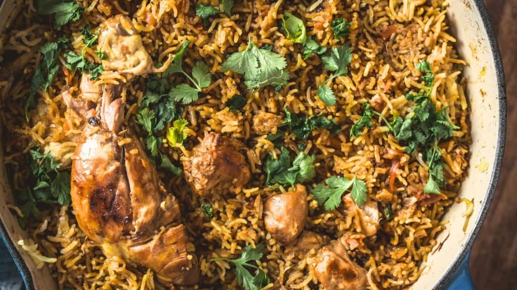 Aromatic chicken biryani garnished with fresh cilantro in a large serving dish.