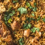 Aromatic chicken biryani garnished with fresh cilantro in a large serving dish.