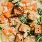 Bowl of vegetable soup with croutons and spinach.