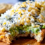 Avocado toast on a wooden cutting board.