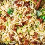 A bowl of pasta with bacon and brussels sprouts.