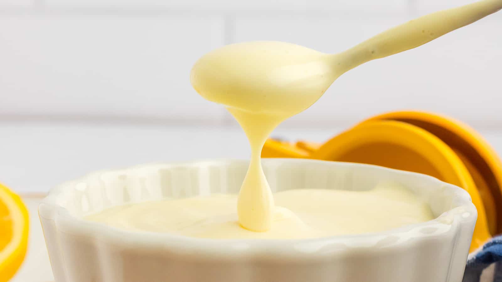 A bowl of mayonnaise with a spoonful.
