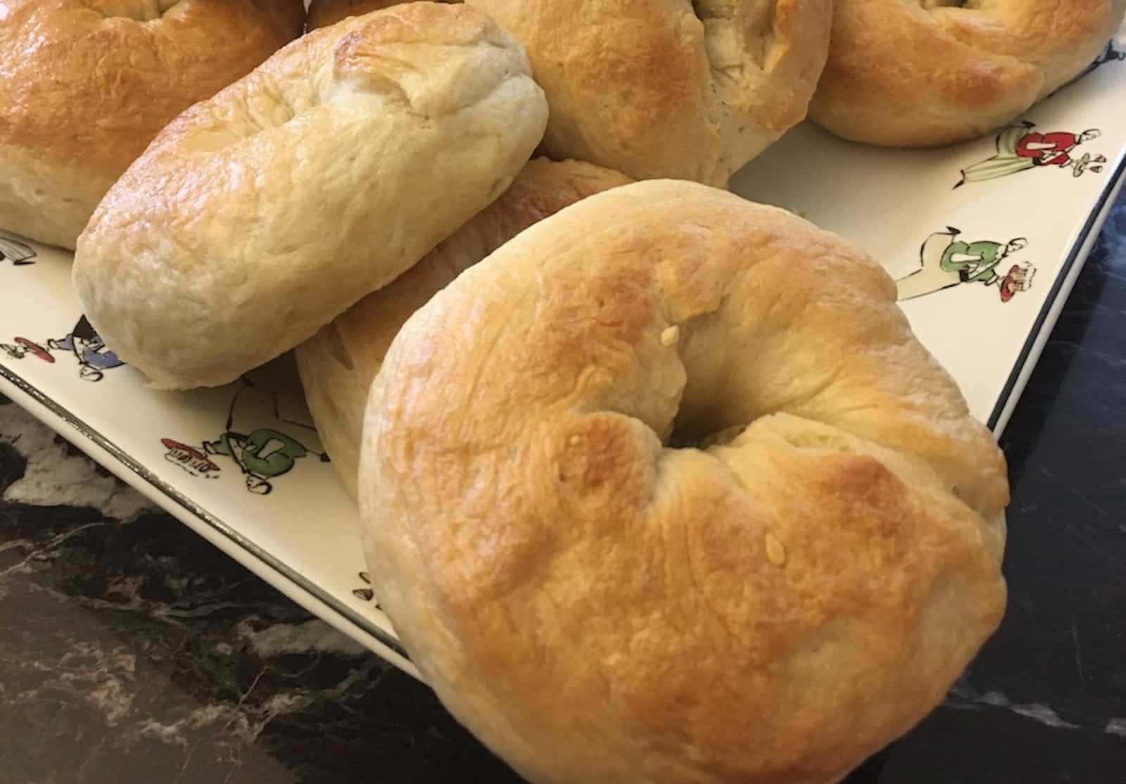 Bagels on a plate on a marble counter.