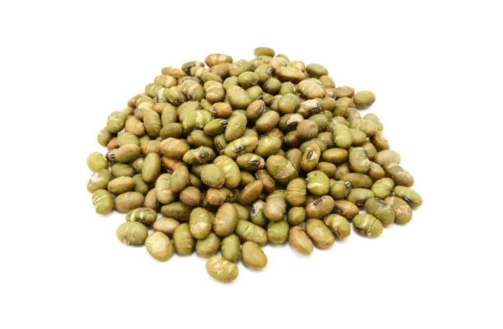 A pile of roasted green soy nuts isolated on a white background.