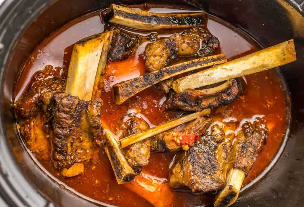 A slow cooker full of meat and vegetables.