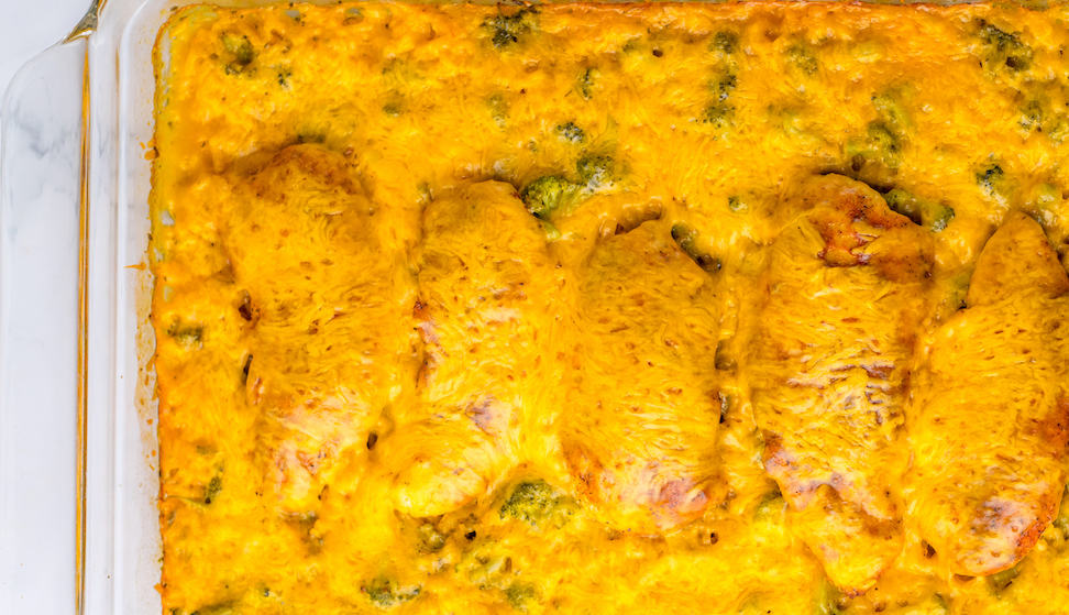A close-up of a baked broccoli and cheese casserole in a white dish.
