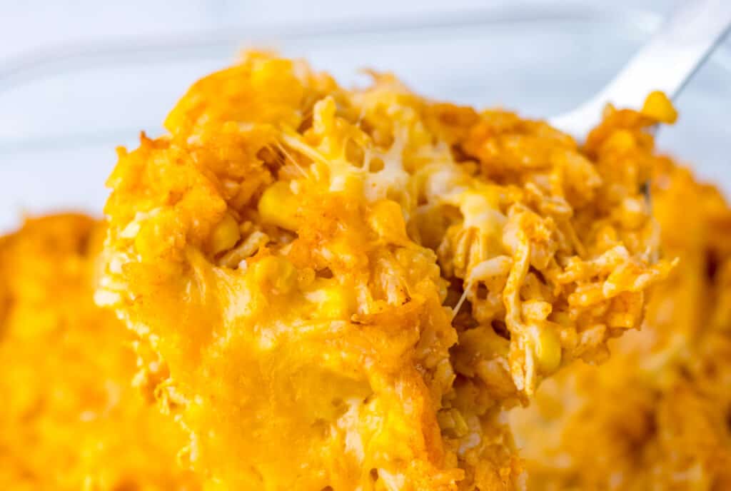 Close-up of cheesy hash brown casserole on a fork.