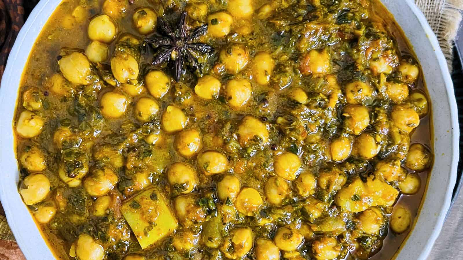 A bowl of Indian Palak chole (Chickpea Spinach Curry) seasoned with spices and herbs.