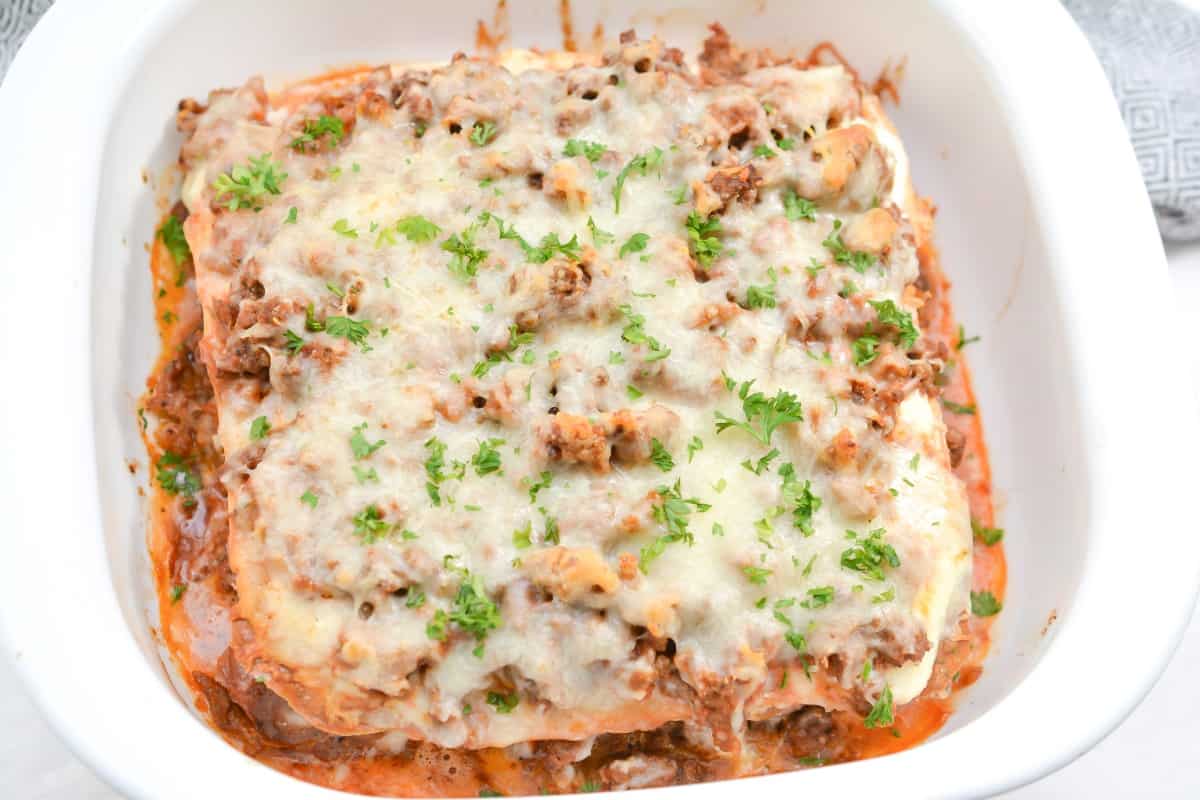 A stack of meat lasagna on a white plate.