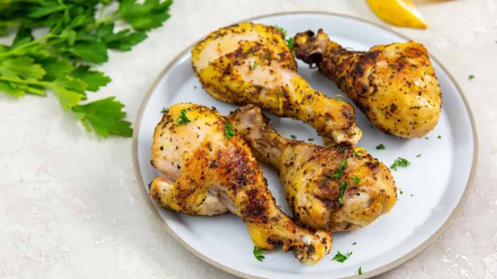 Air Fryer Lemon Pepper Chicken Legs on a white plate with parsley.