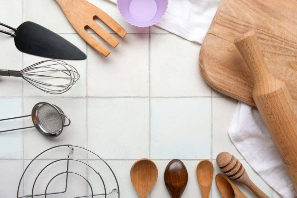 Assorted low carb essentials and kitchen utensils arranged on a tiled countertop.