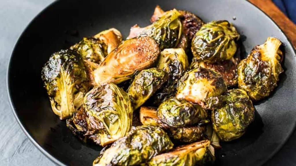 Garam masala brussels sprouts on a black plate.