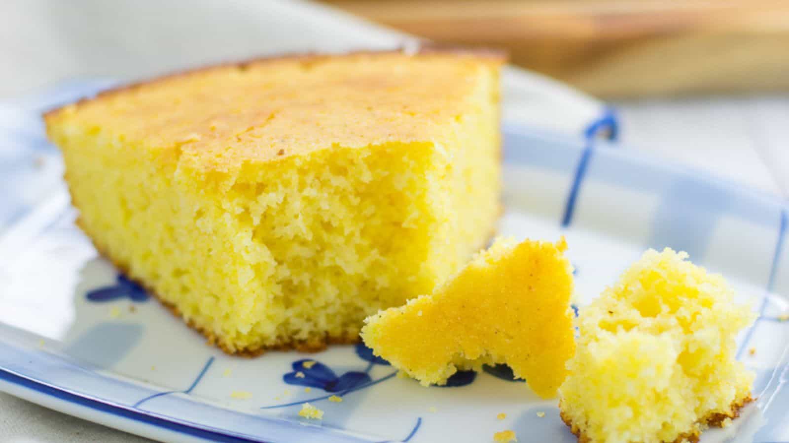 Overhead shot of cornbread in a cast iron skillet with a single slice cut out.