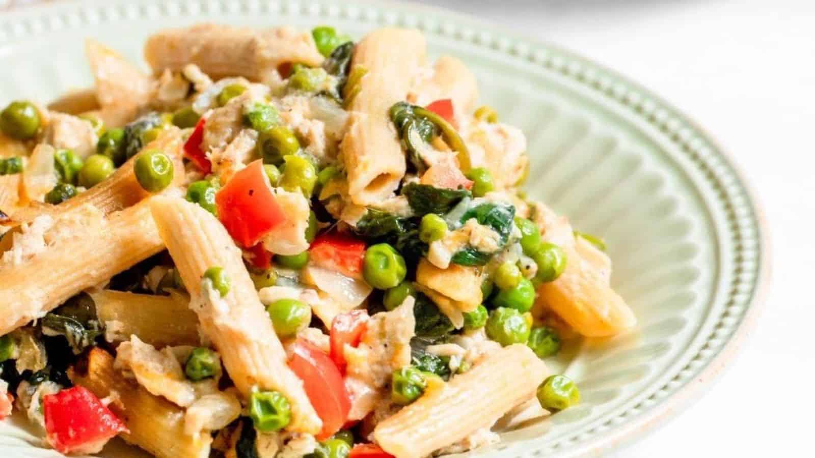 Tuna noodle casserole with vegetables in a shallow light green bowl.