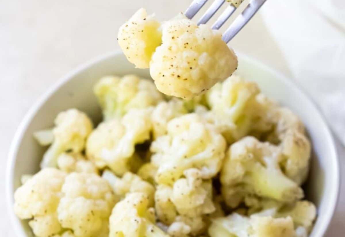 Instant Pot Cauliflower in a white bowl with a fork.