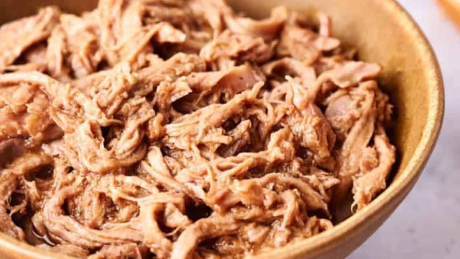 A bowl containing pulled pork.