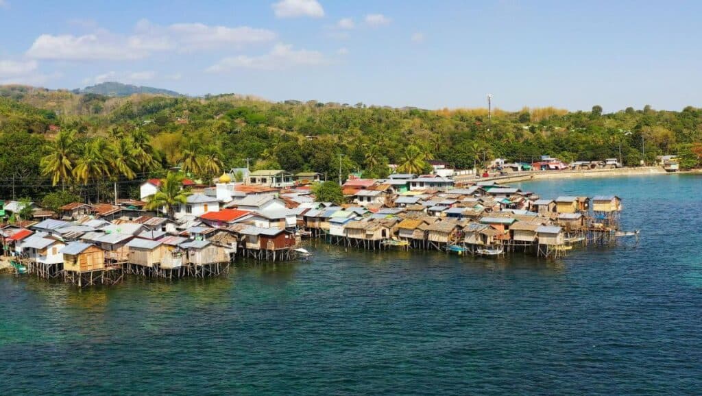 Aerial view of a stilt village by the sea with densely packed houses, one of the must-visit places in the Philippines.
