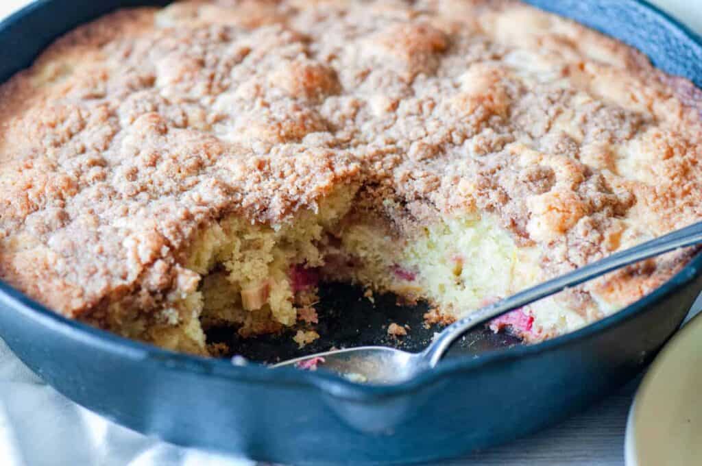 A pan of rhubarb cake with a scoop out of it. 