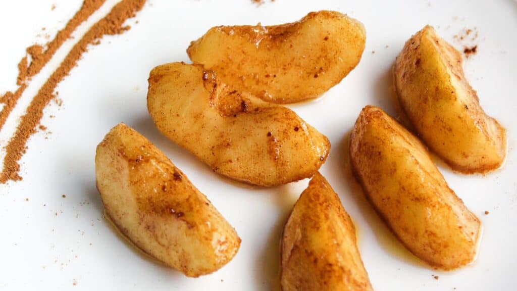 Air-fried cinnamon apples on a white plate.