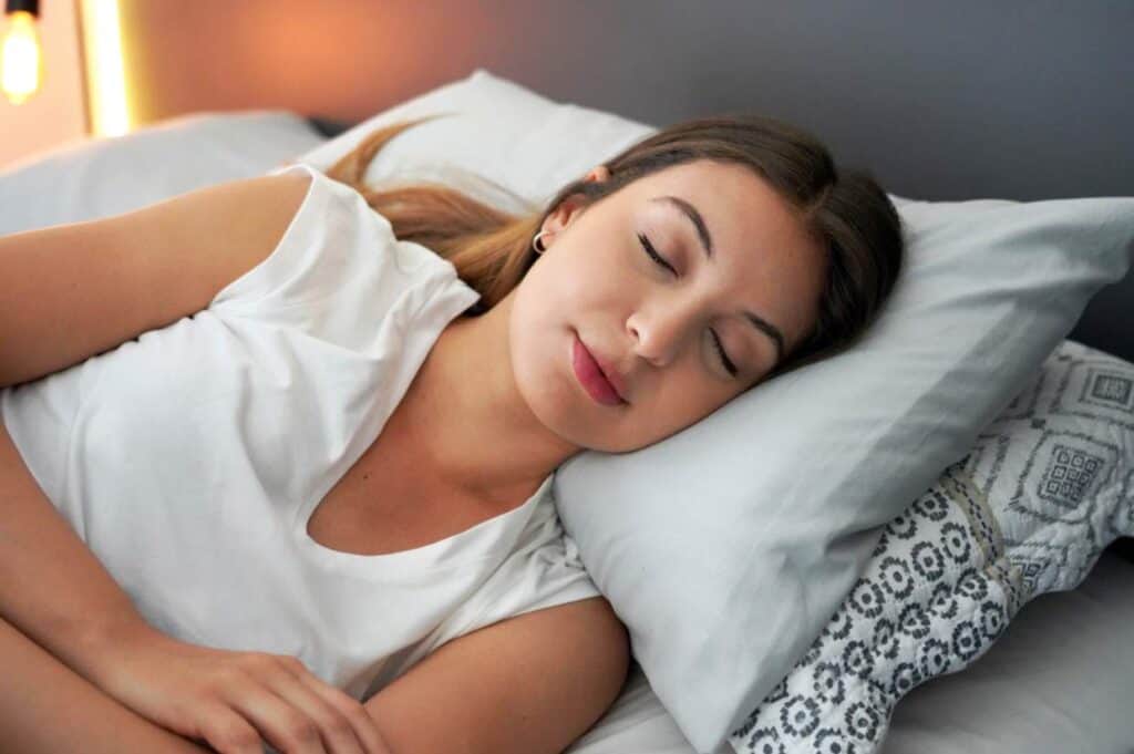 Woman sleeping peacefully in bed, her circadian rhythm perfectly aligned.